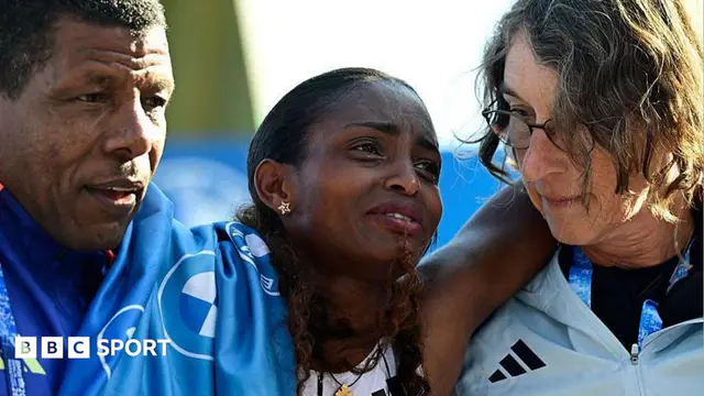 Ethiopia's Tigst Assefa (C) is helped off the track after crossing the finish line to win the women's race of 52nd Berlin Marathon in Berlin, Germany on September 27, 2026.