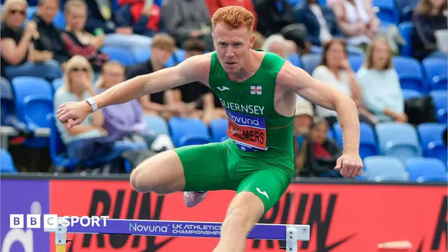 Alastair Chalmers jumps over a hurdle while competing. He is wearing a green Guernsey-branded sleeveless top and shorts