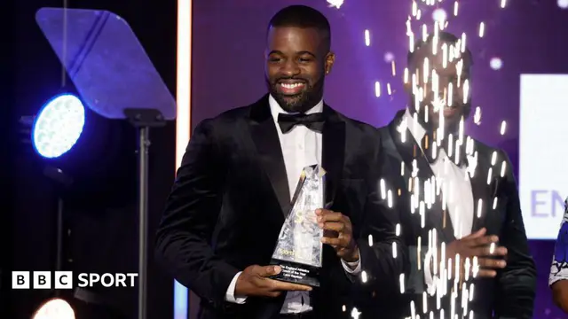 UK Athletics sprinting coach Leon Baptiste collects an award for coach of the year at a 2023 awards ceremony