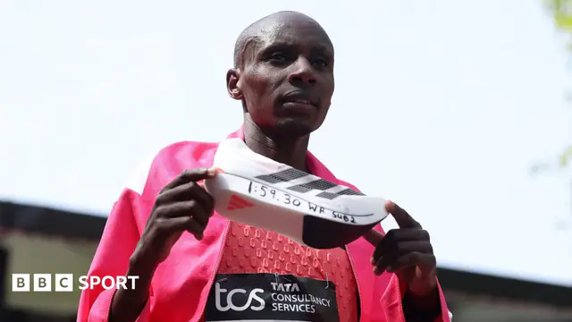 Sabastian Sawe holding up his shoe in celebration